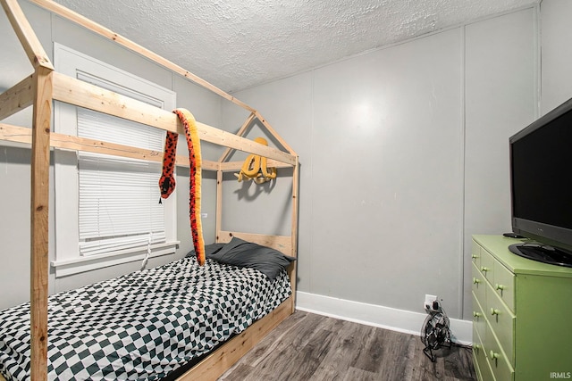 bedroom with dark hardwood / wood-style floors and a textured ceiling