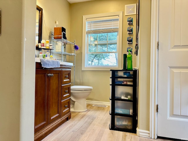 bathroom featuring toilet, vanity, and hardwood / wood-style flooring