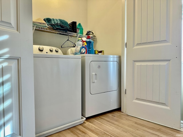 clothes washing area featuring light hardwood / wood-style flooring and washing machine and clothes dryer