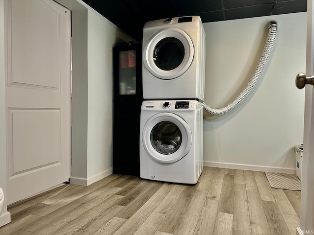 laundry room with light hardwood / wood-style floors and stacked washer and clothes dryer