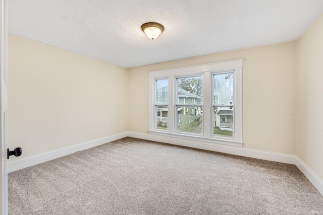 carpeted spare room featuring a textured ceiling