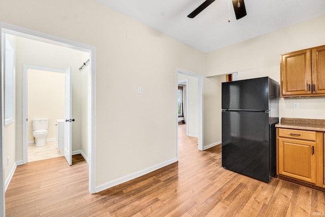 kitchen featuring light hardwood / wood-style flooring, black fridge, and ceiling fan