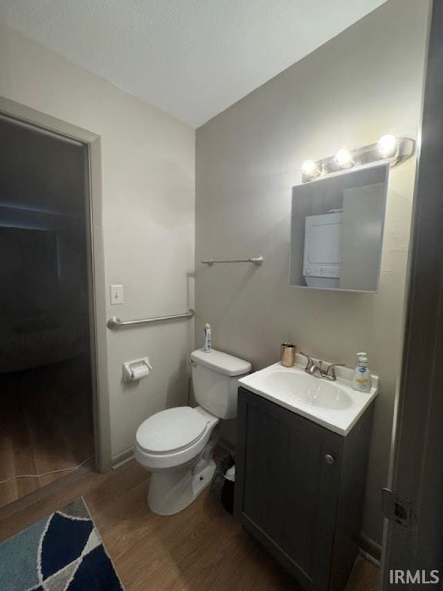 bathroom with vanity, wood-type flooring, and toilet