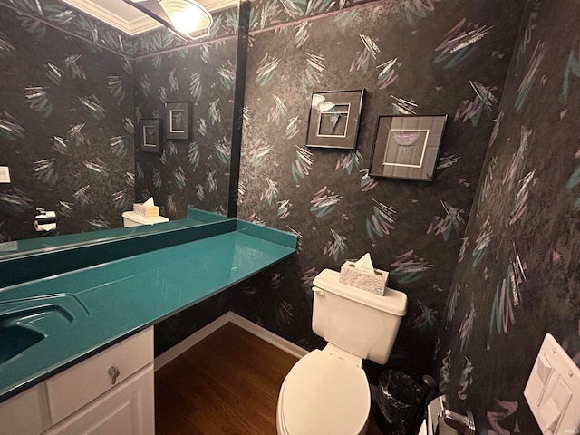 bathroom featuring toilet, hardwood / wood-style floors, vanity, and ornamental molding