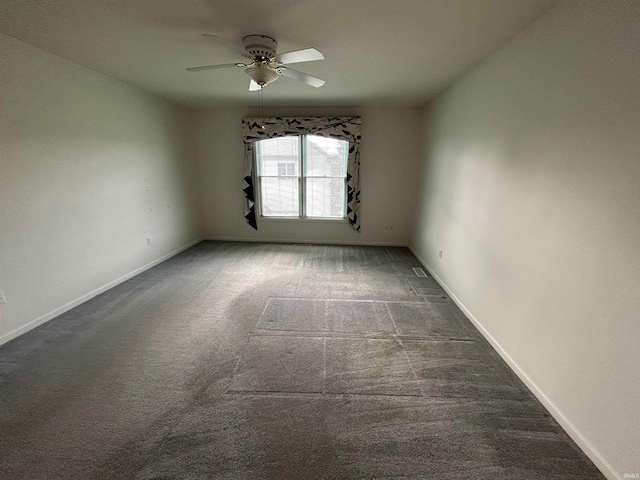 empty room with dark colored carpet and ceiling fan