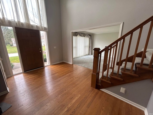 entryway featuring a towering ceiling and light hardwood / wood-style flooring