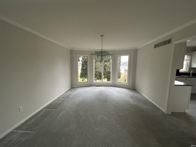 unfurnished dining area with crown molding, a chandelier, and dark colored carpet