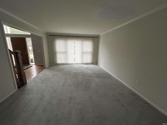 unfurnished living room featuring carpet, a wealth of natural light, and crown molding