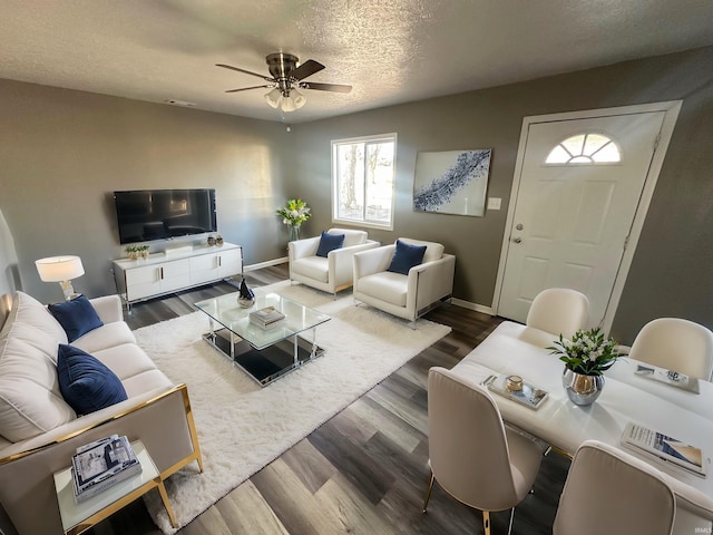 living room featuring hardwood / wood-style floors, a textured ceiling, and ceiling fan