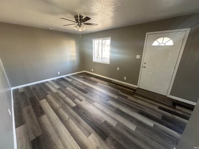 foyer entrance featuring ceiling fan, dark wood-type flooring, and a textured ceiling