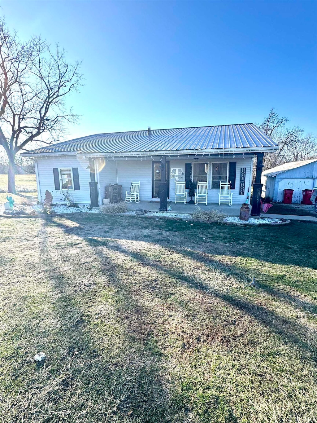 ranch-style house with covered porch and a front lawn