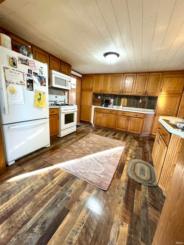 kitchen with dark hardwood / wood-style floors and white appliances