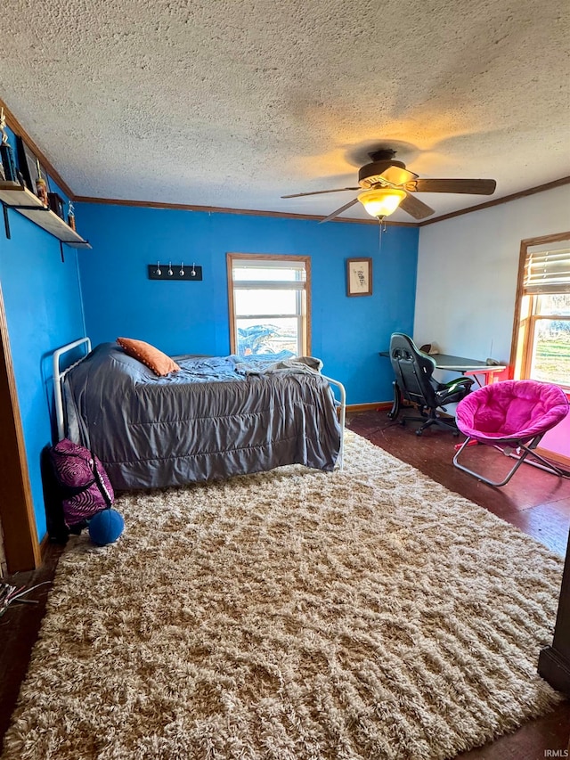 carpeted bedroom with multiple windows, ceiling fan, crown molding, and a textured ceiling