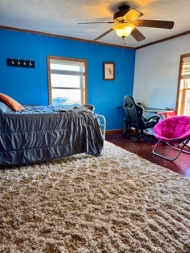 bedroom with dark colored carpet, a textured ceiling, ceiling fan, and ornamental molding