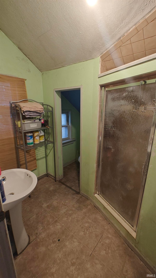 bathroom featuring tile patterned floors, a textured ceiling, and vaulted ceiling