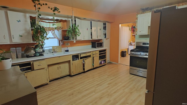 kitchen with sink, stainless steel appliances, and light wood-type flooring