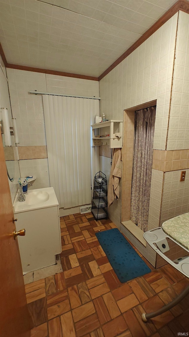 bathroom featuring crown molding, sink, parquet floors, and tile walls