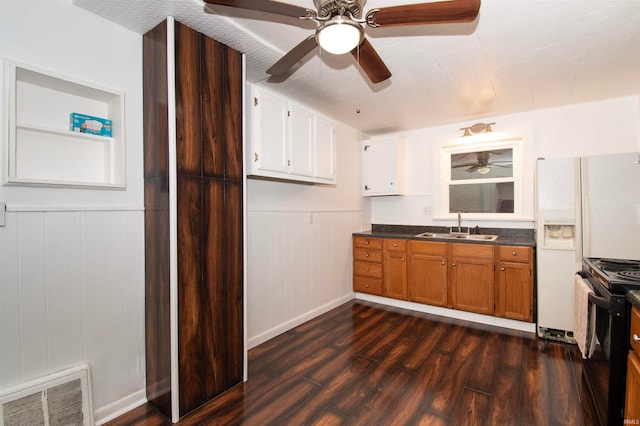 kitchen with dark wood-type flooring, sink, black gas stove, white cabinetry, and white fridge with ice dispenser