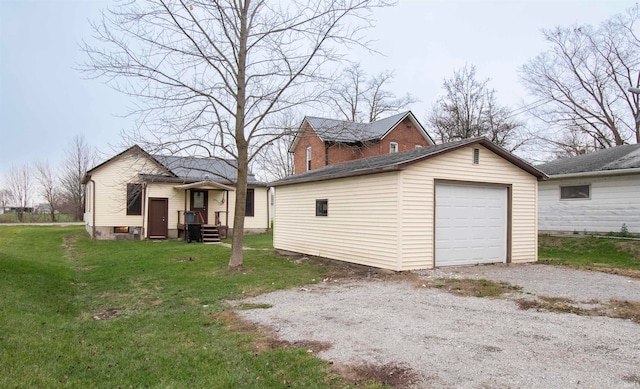 view of property exterior featuring a lawn, a garage, and an outdoor structure