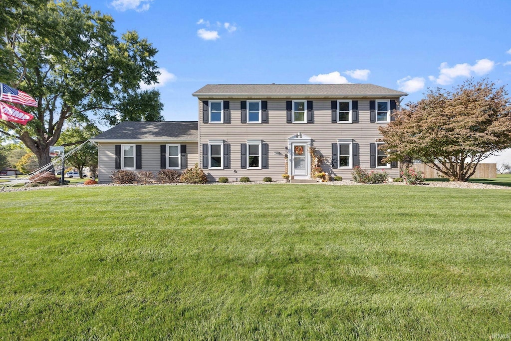 colonial-style house featuring a front lawn