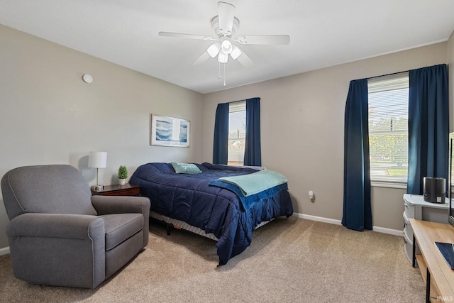 bedroom featuring ceiling fan, light colored carpet, and multiple windows