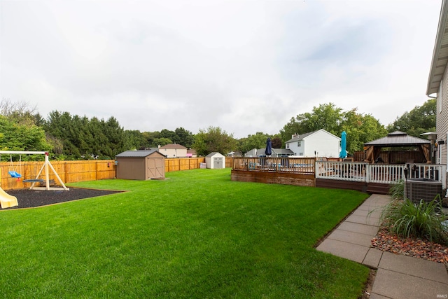 view of yard featuring a gazebo, a playground, and a storage unit