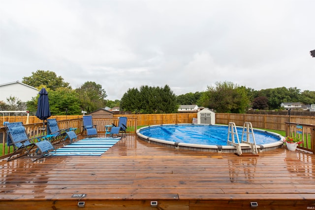 view of pool featuring a storage shed and a wooden deck