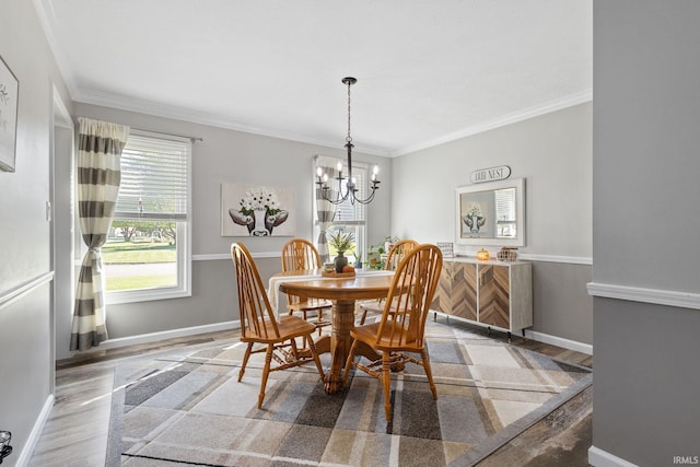 dining space with crown molding, an inviting chandelier, and hardwood / wood-style flooring