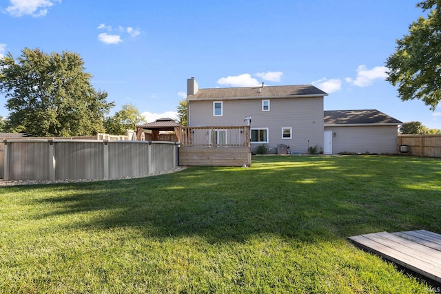 back of house with a yard and a wooden deck