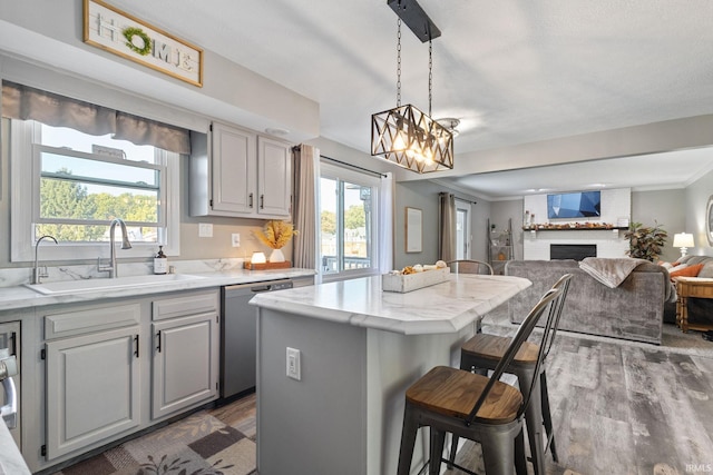 kitchen featuring dishwasher, a center island, a healthy amount of sunlight, and gray cabinetry