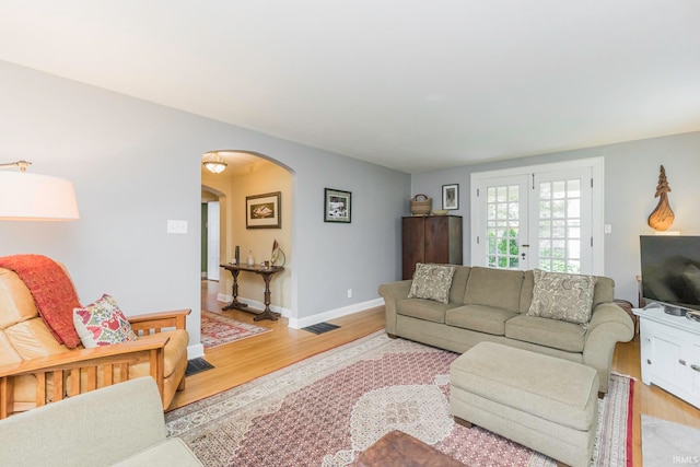 living room featuring french doors and light wood-type flooring