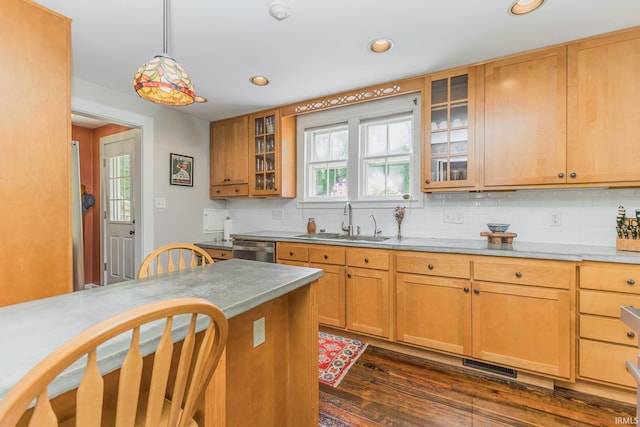 kitchen with pendant lighting, dishwasher, sink, dark hardwood / wood-style floors, and tasteful backsplash