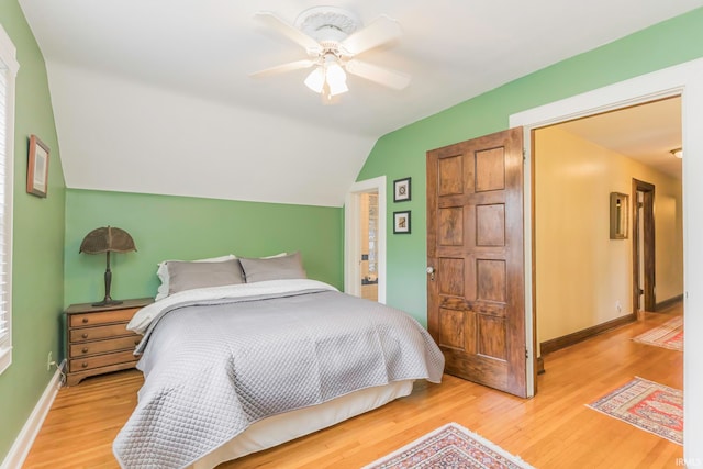 bedroom with ceiling fan, vaulted ceiling, and hardwood / wood-style flooring