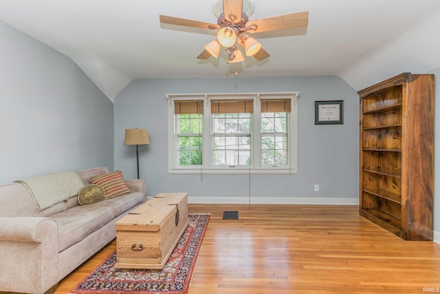 living room featuring ceiling fan, light wood-type flooring, and lofted ceiling