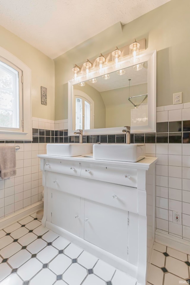 bathroom featuring vanity and tile walls