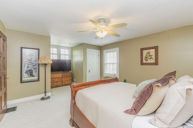 bedroom featuring a closet, light colored carpet, and ceiling fan