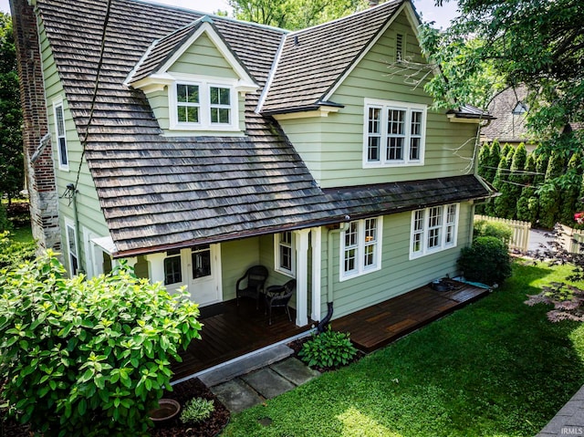 back of property featuring a lawn and a wooden deck