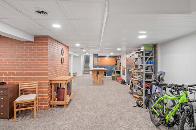 game room with carpet floors and brick wall