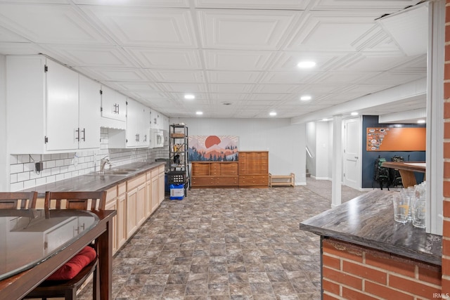 kitchen featuring backsplash, white cabinetry, and sink