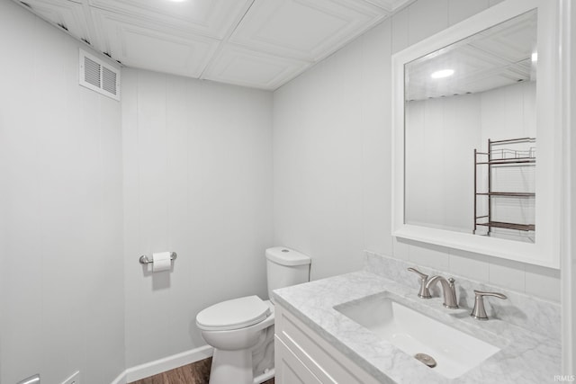 bathroom featuring wood-type flooring, vanity, and toilet