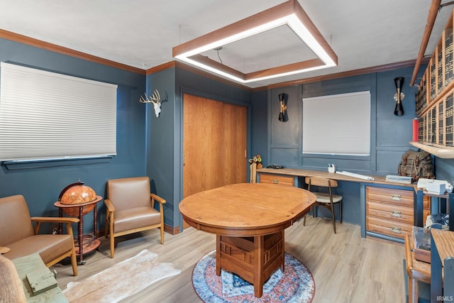 interior space with a raised ceiling, ornamental molding, and light hardwood / wood-style flooring