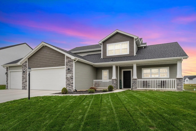 craftsman-style home featuring a lawn, covered porch, and a garage