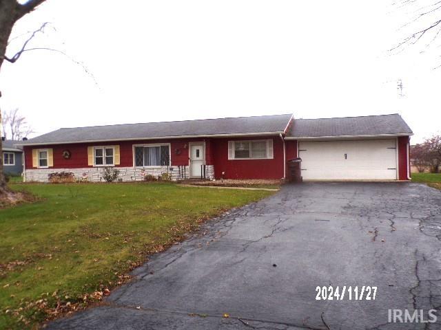 ranch-style home with a garage and a front lawn