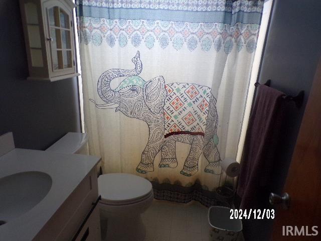 bathroom with vanity, curtained shower, and toilet