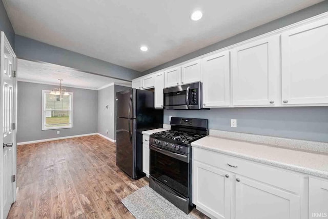 kitchen with white cabinets, black appliances, and light wood-type flooring