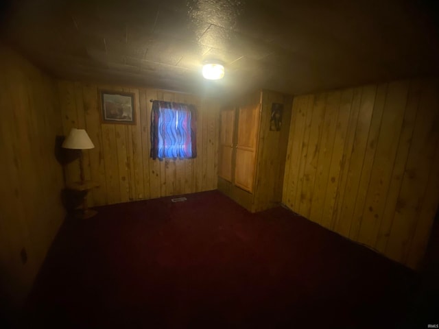 basement with carpet and wooden walls