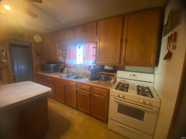 kitchen featuring white range with gas cooktop, ceiling fan, and sink