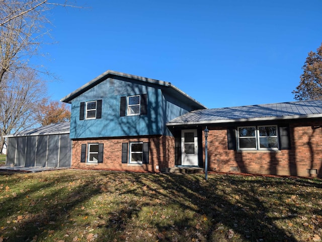 tri-level home with a front lawn and a sunroom