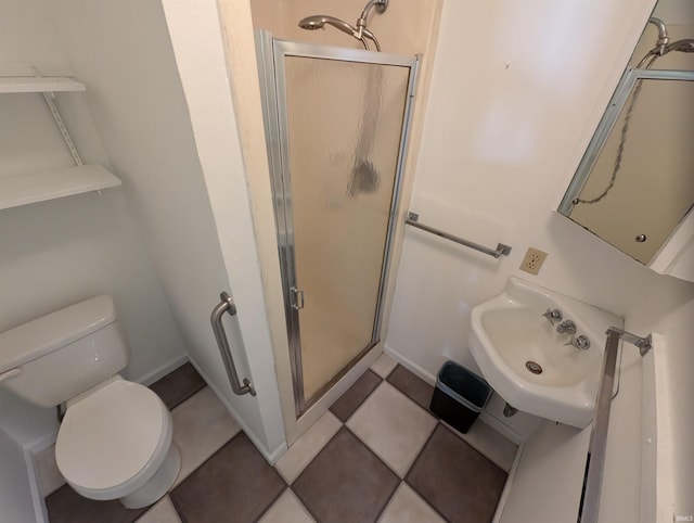 bathroom with tile patterned floors, toilet, sink, and walk in shower