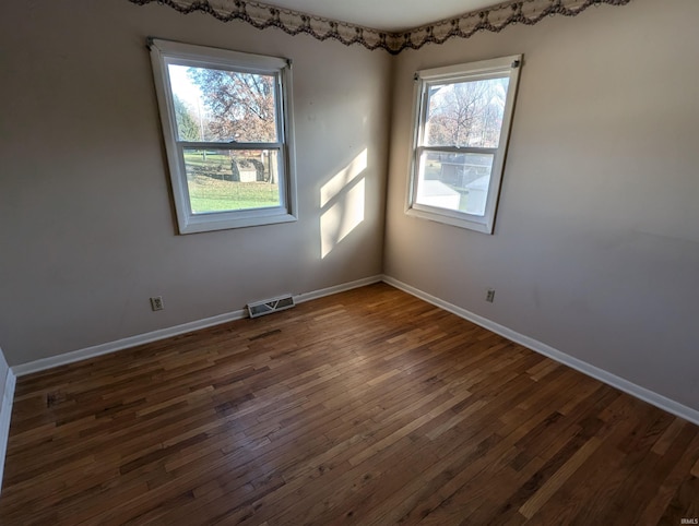 unfurnished room with dark hardwood / wood-style floors and plenty of natural light